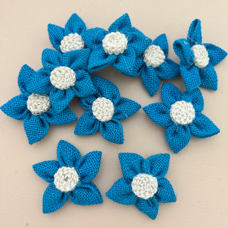 Pack of blue jute burlap flower patches spread on beige background