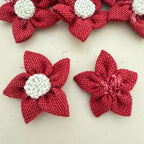 Close-up of two red jute burlap flower patches showing front and back