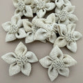 Pack of natural white jute burlap flower patches spread on grey background