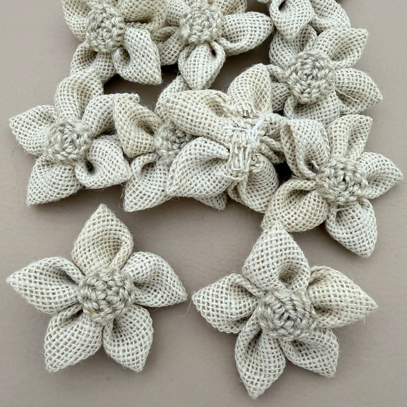 Pack of natural white jute burlap flower patches spread on grey background