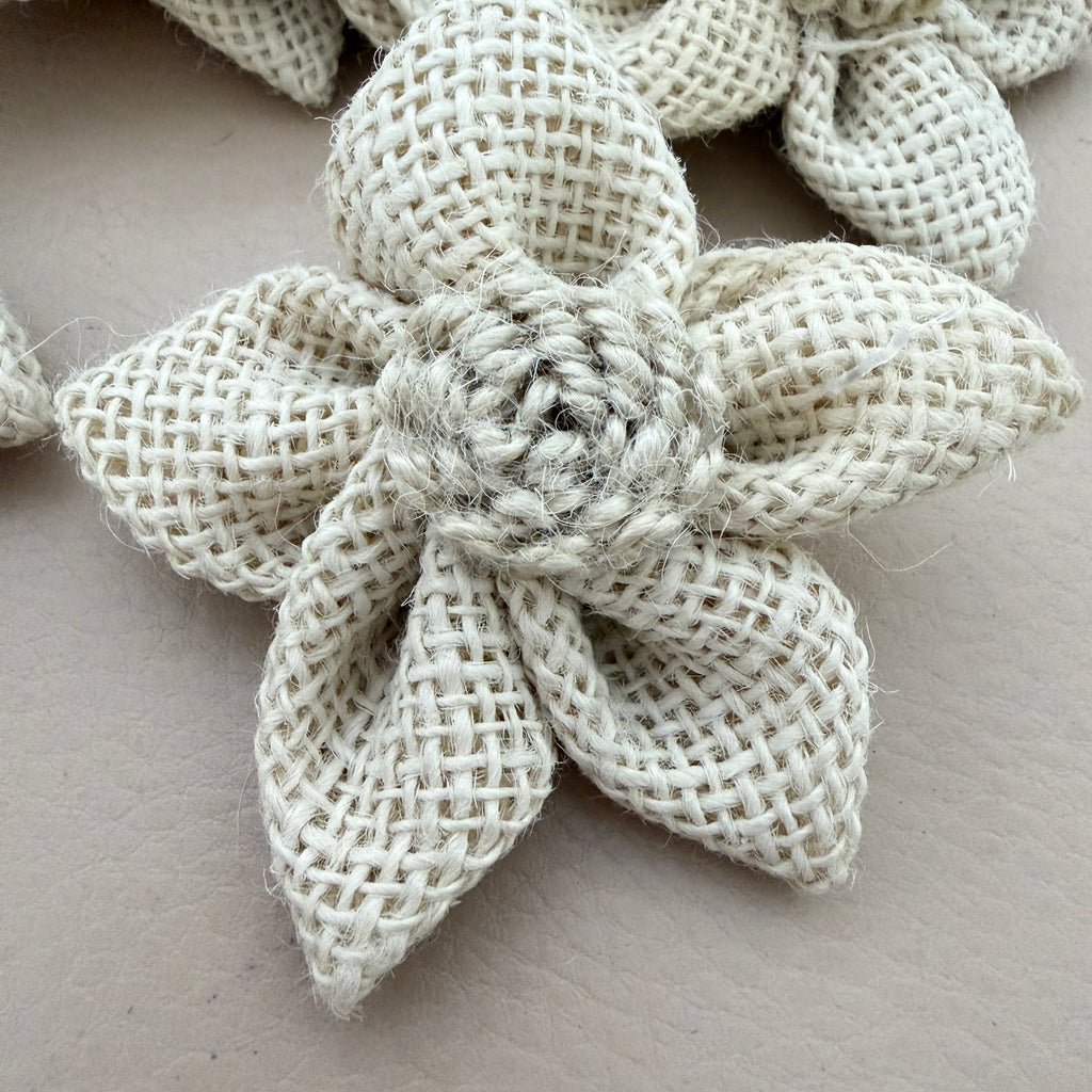 Close-up of natural white jute burlap flower patch showing rope rosette centre detail