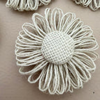 Close-up of single jute twine daisy showing looped petals and woven burlap dome centre