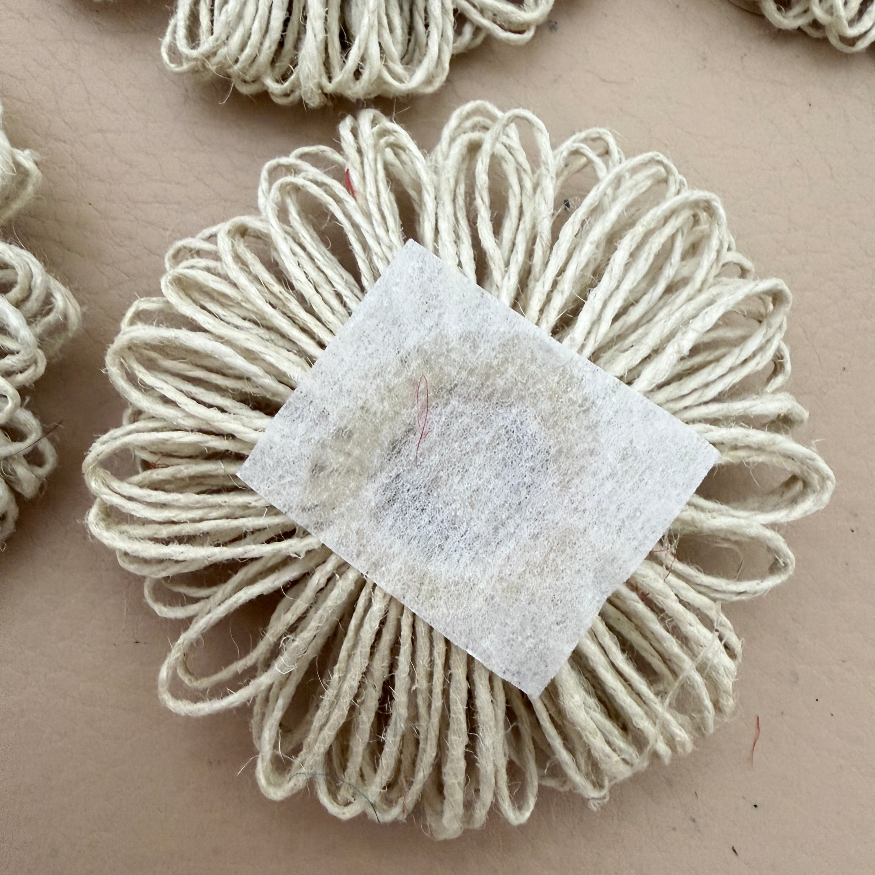 Back view of jute twine daisy patch showing white felt square backing