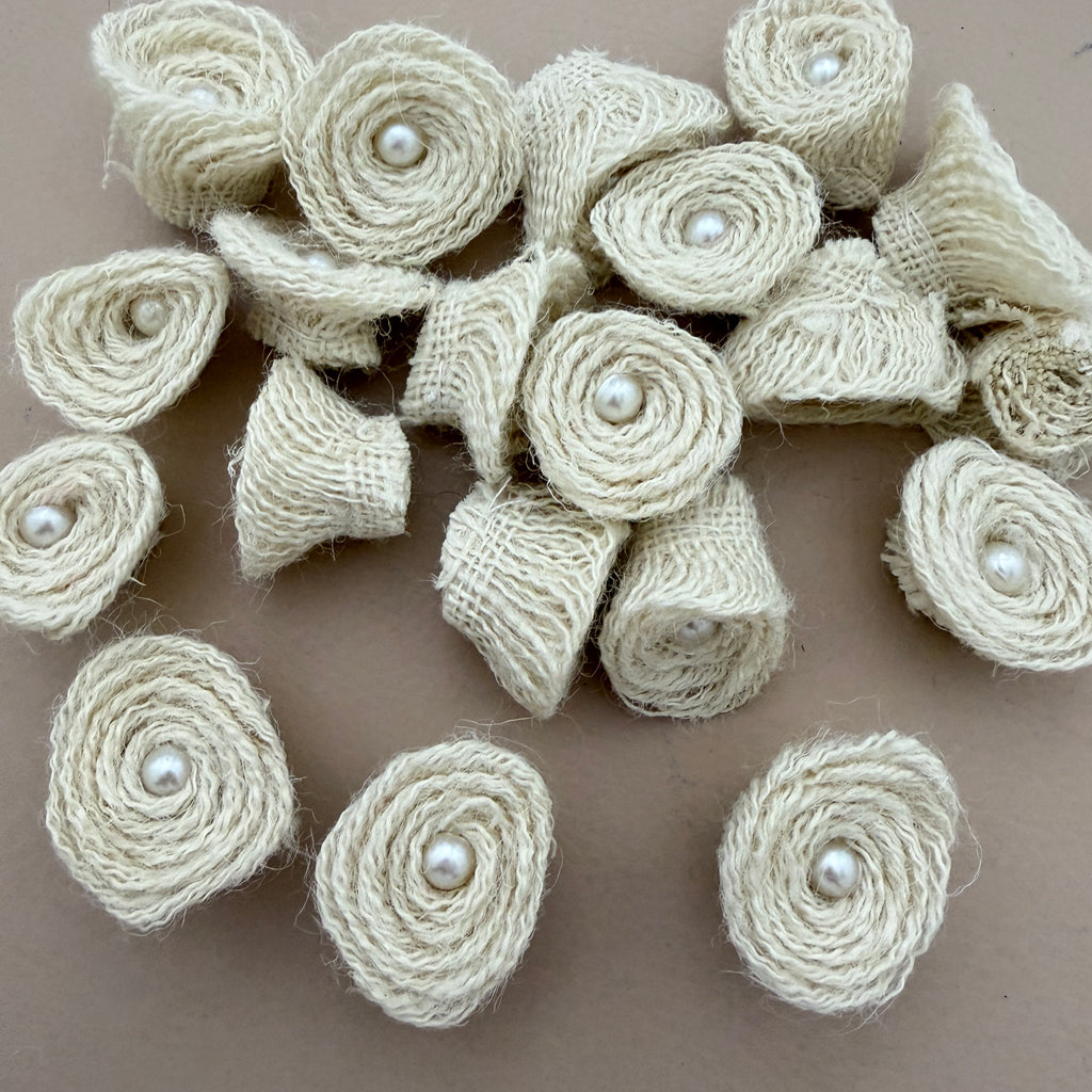 Pack of handmade jute rope rosette patches with pearl centres spread on beige background