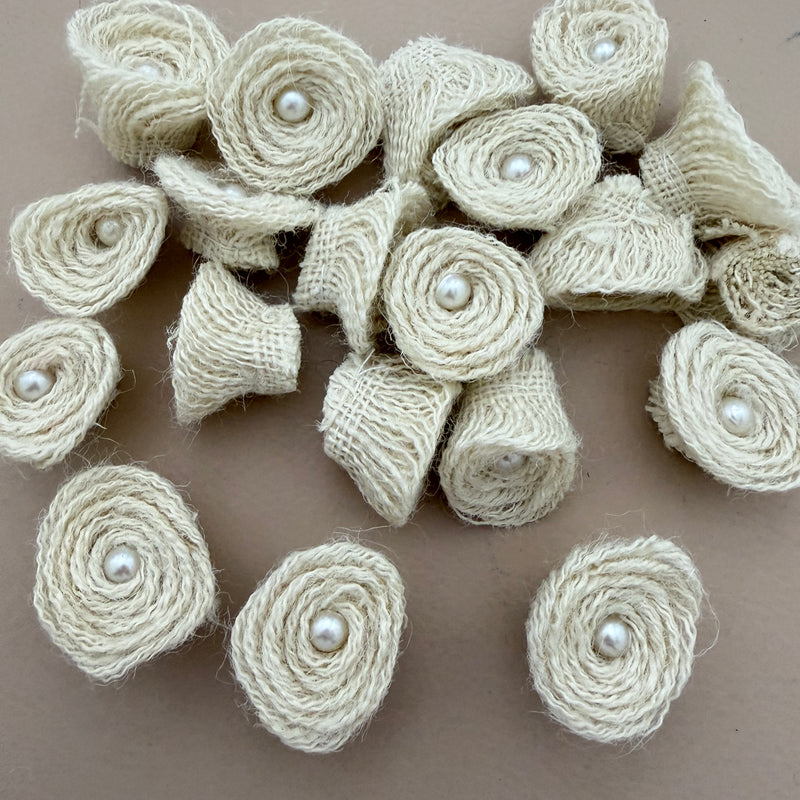 Pack of handmade jute rope rosette patches with pearl centres spread on beige background