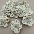 Pack of 3D puffed burlap flower patches spread on grey background