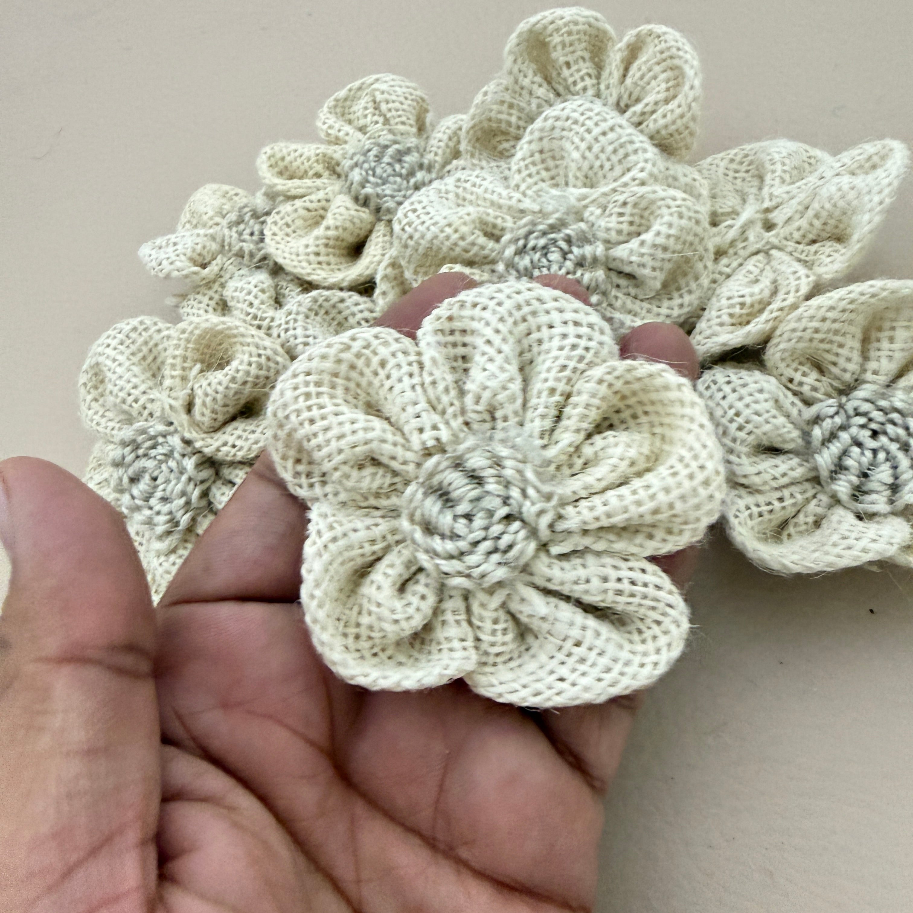 3D puffed burlap flower patches held in hand showing size and texture