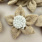 Multiple jute burlap flower patches held in hand showing size