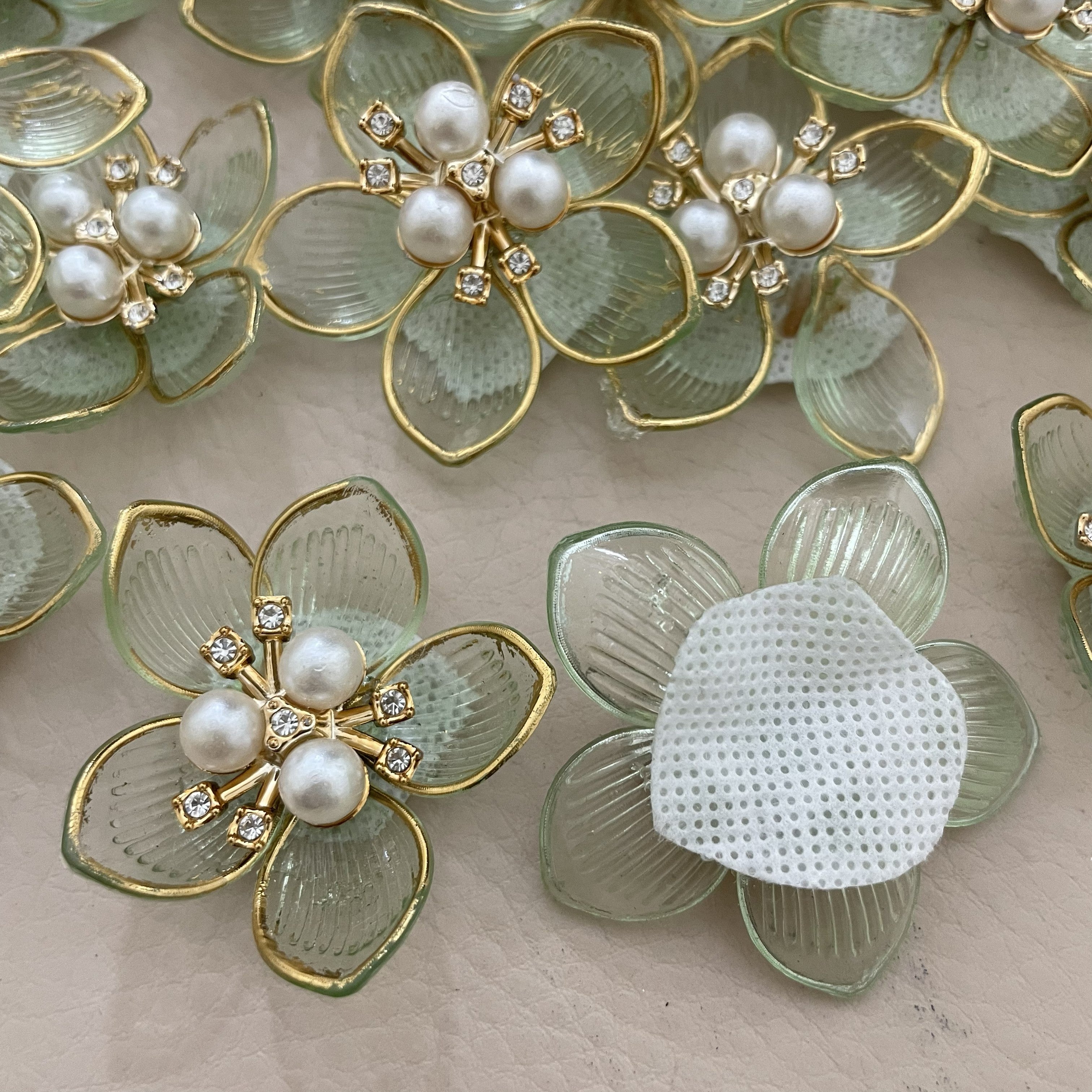 Mint green pearl flower patch held in hand
