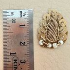 Gold zardozi patch held in hand for scale
