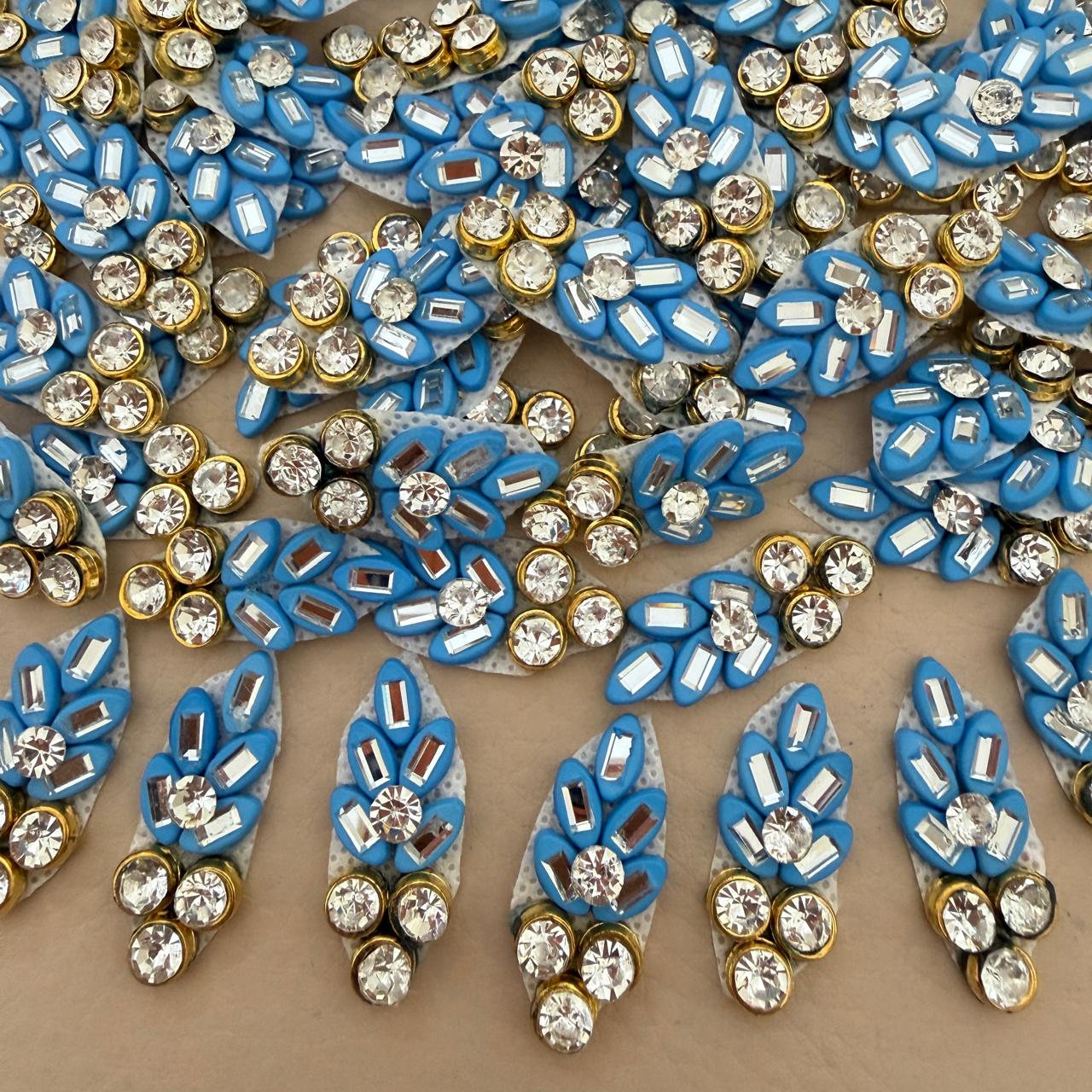 Front and back view of blue rhinestone leaf patch showing mesh backing