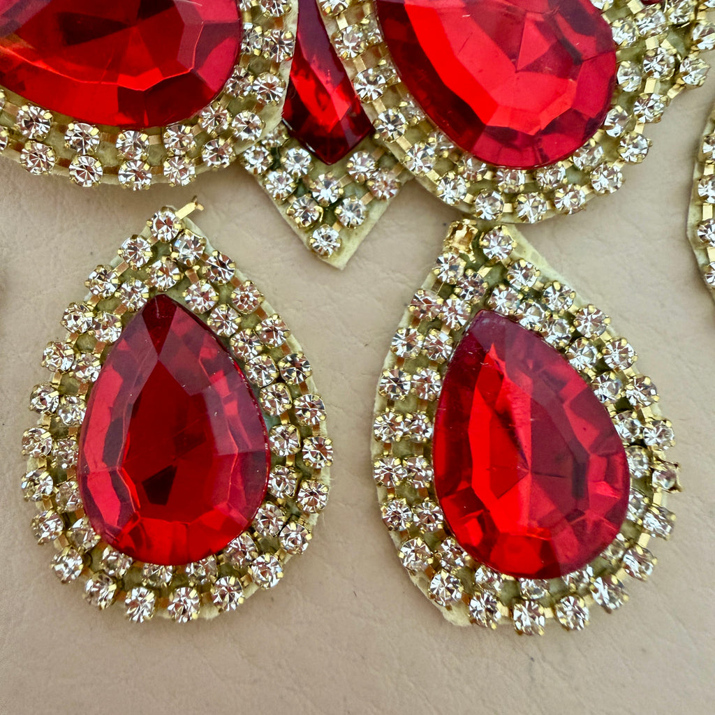Close-up of two red teardrop rhinestone patches showing crystal detail