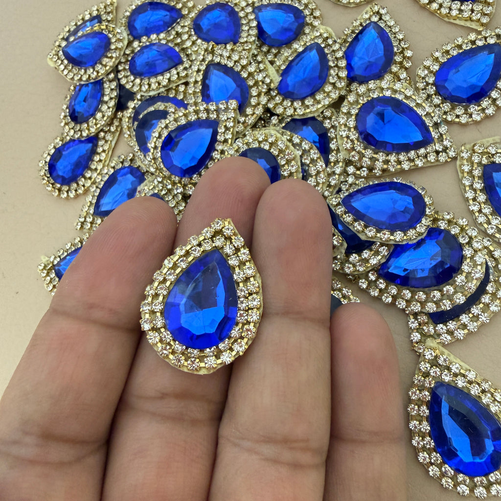Single royal blue teardrop patch held in hand showing size reference