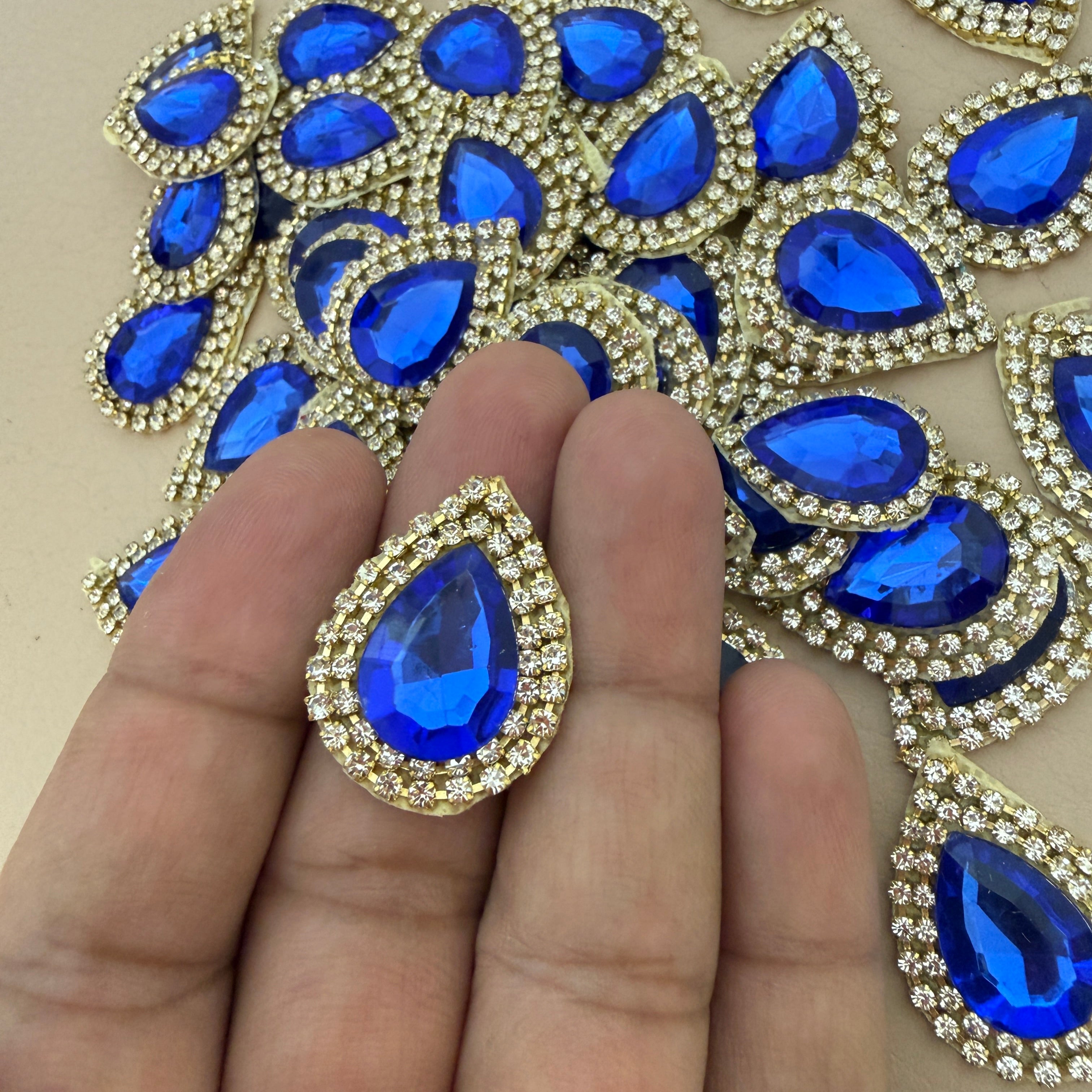 Single royal blue teardrop patch held in hand showing size reference