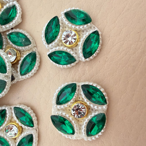 Close-up of emerald green rhinestone flower patch showing marquise stones and pearl border