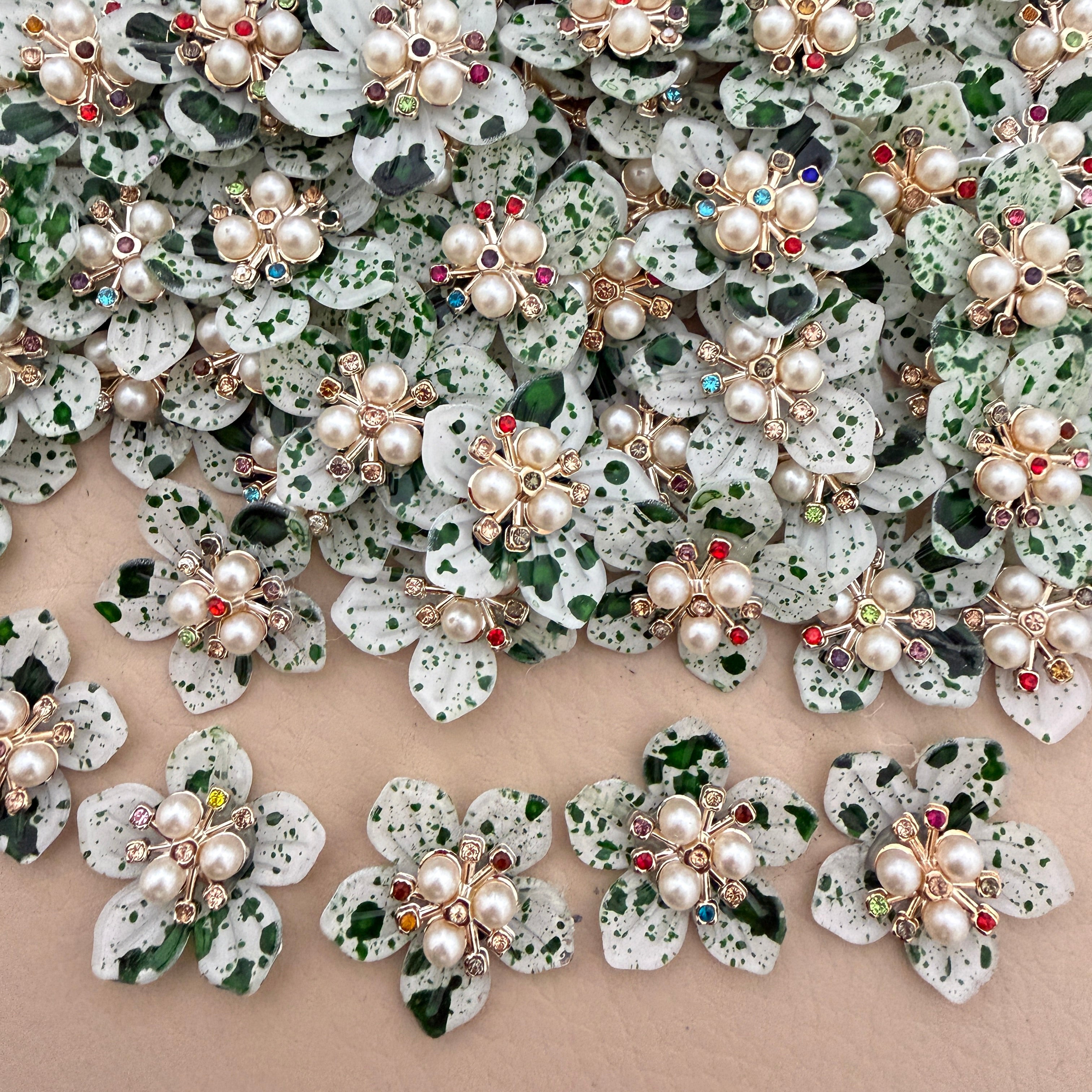 Green speckle pearl rhinestone flower patches – bulk lot overhead view