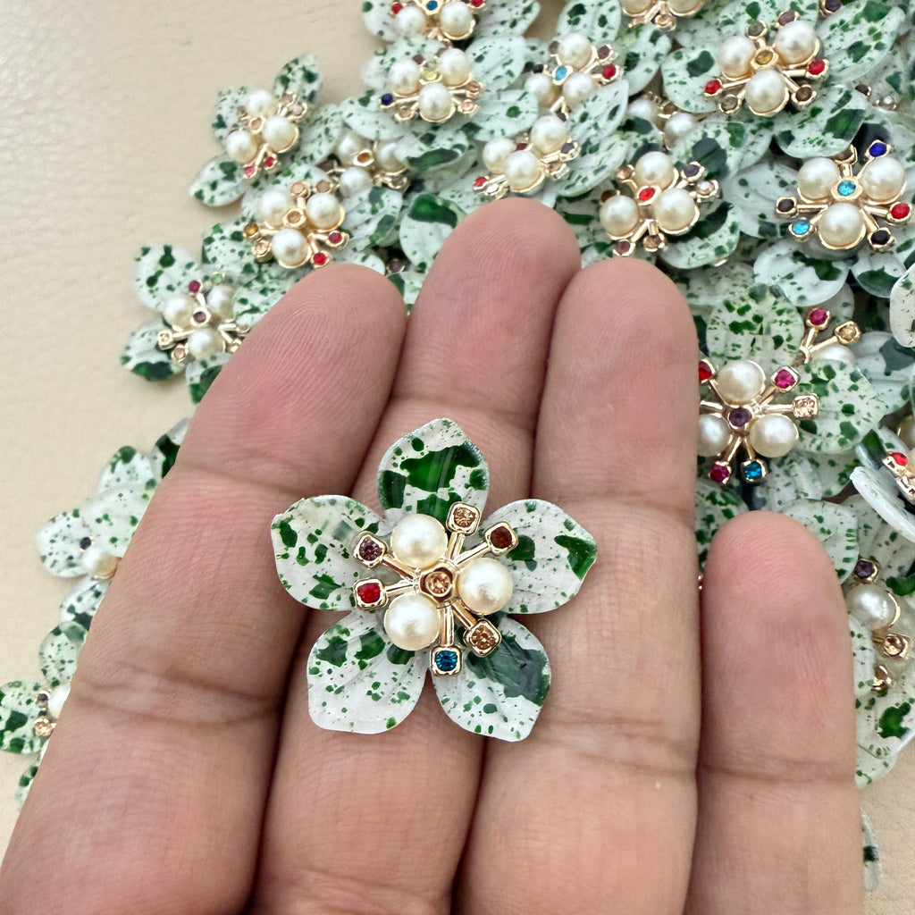 Green speckle pearl flower patch held in hand showing scale against bulk lot