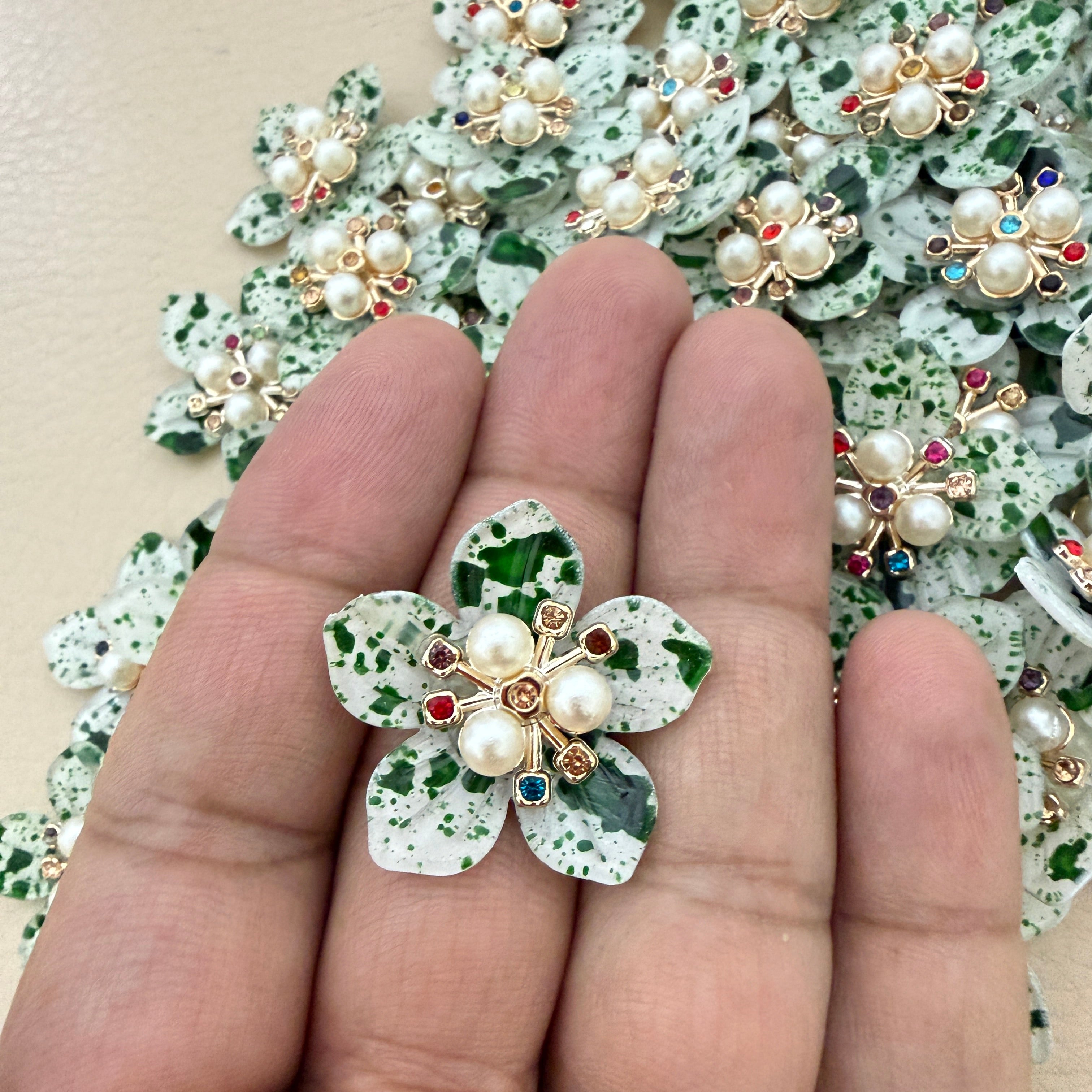 Green speckle pearl flower patch held in hand showing scale against bulk lot