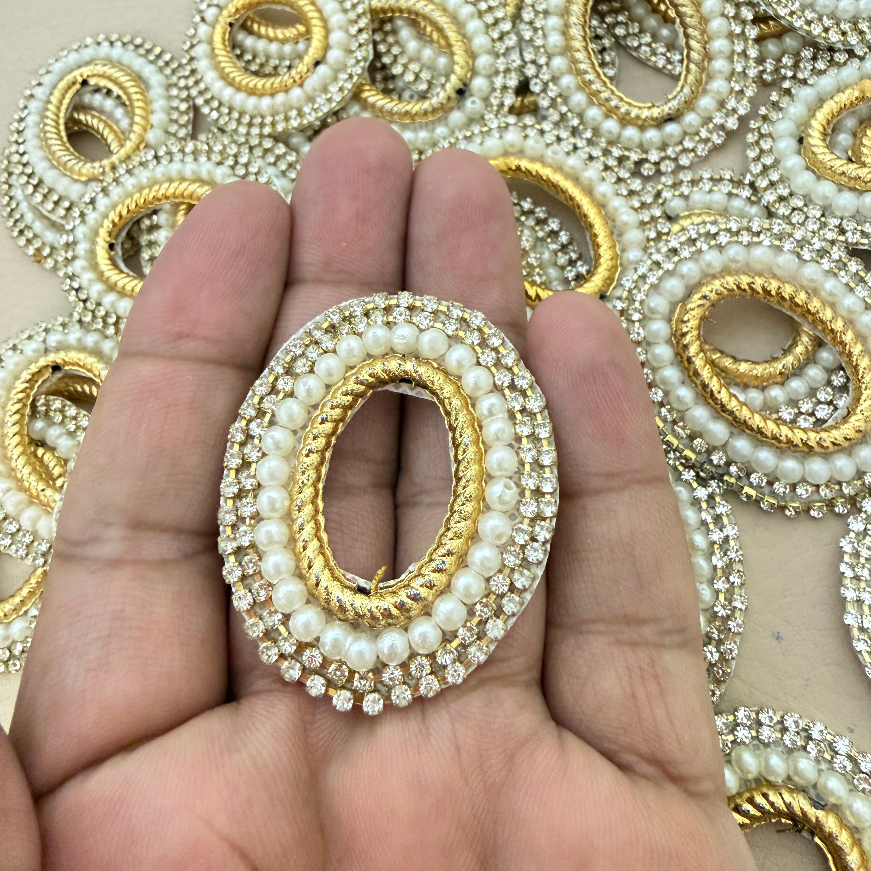 Oval Pearl Rhinestone Patch held in hand showing bulk stock