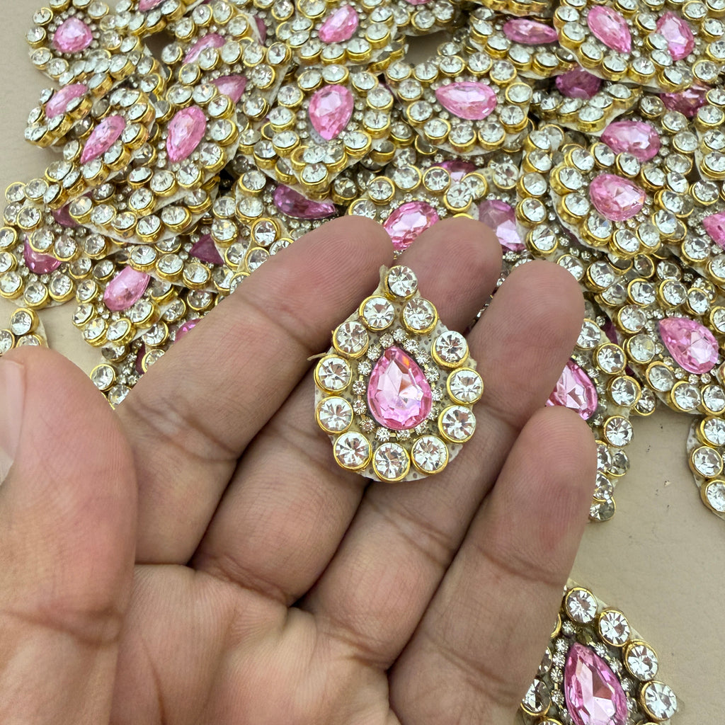 Pink rhinestone crystal patch held in hand showing scale