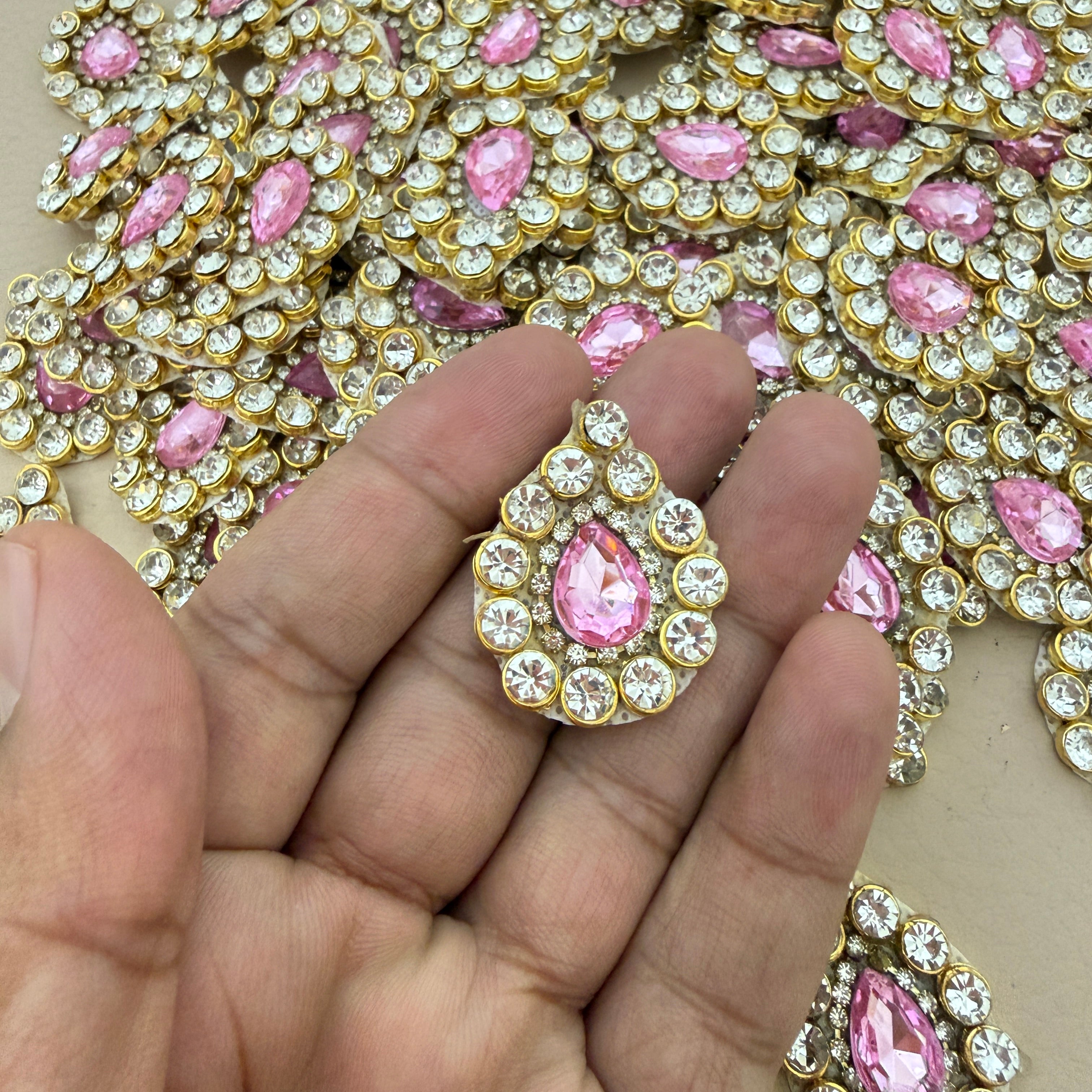 Pink rhinestone crystal patch held in hand showing scale