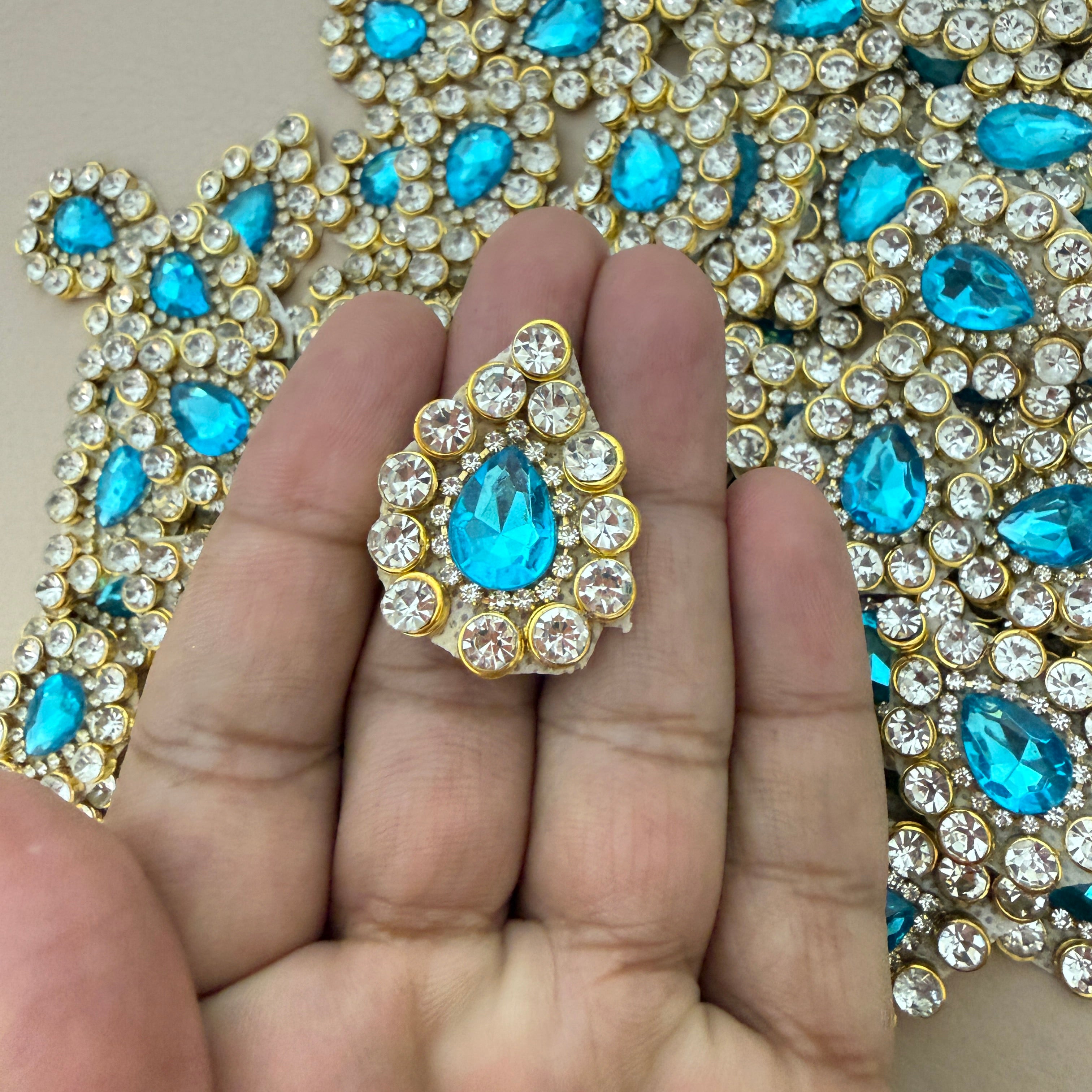 Aqua blue rhinestone crystal patch held in hand showing scale