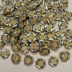 Antique gold rhinestone flower motif patch held in hand showing size