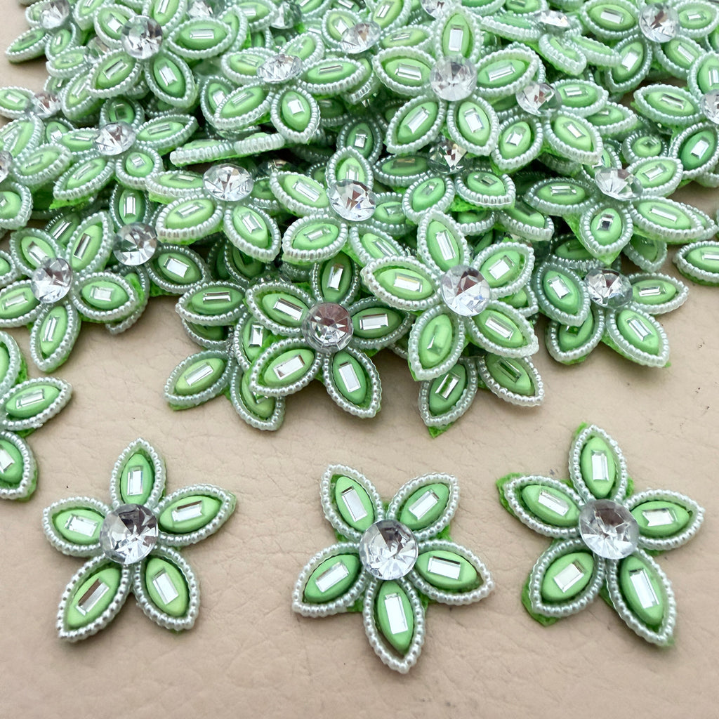 Bulk lot of mint green rhinestone flower motif patches spread out on surface