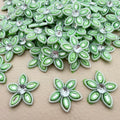 Bulk lot of mint green rhinestone flower motif patches spread out on surface