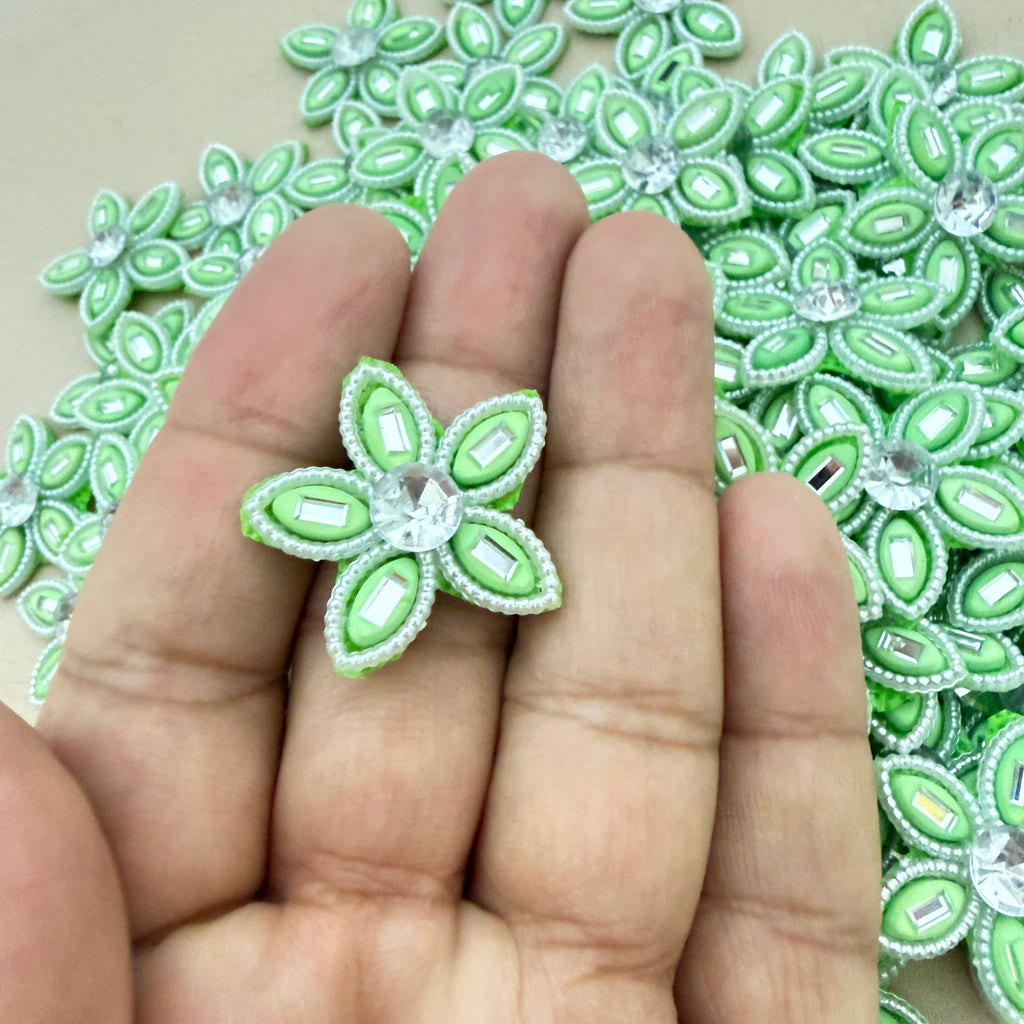 Mint green rhinestone flower motif patch held in hand showing size