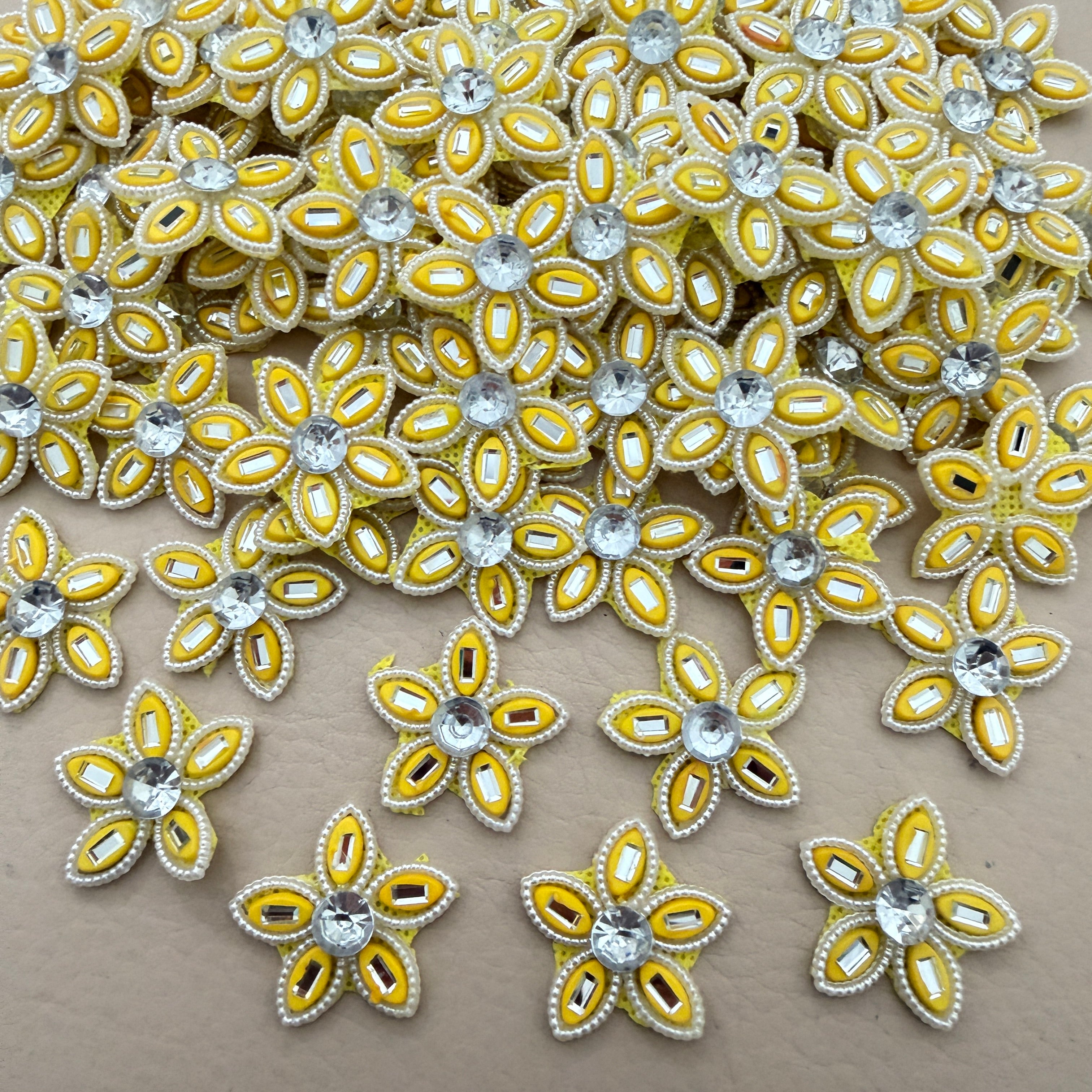 Bulk lot of yellow rhinestone star flower motif patches spread out on surface
