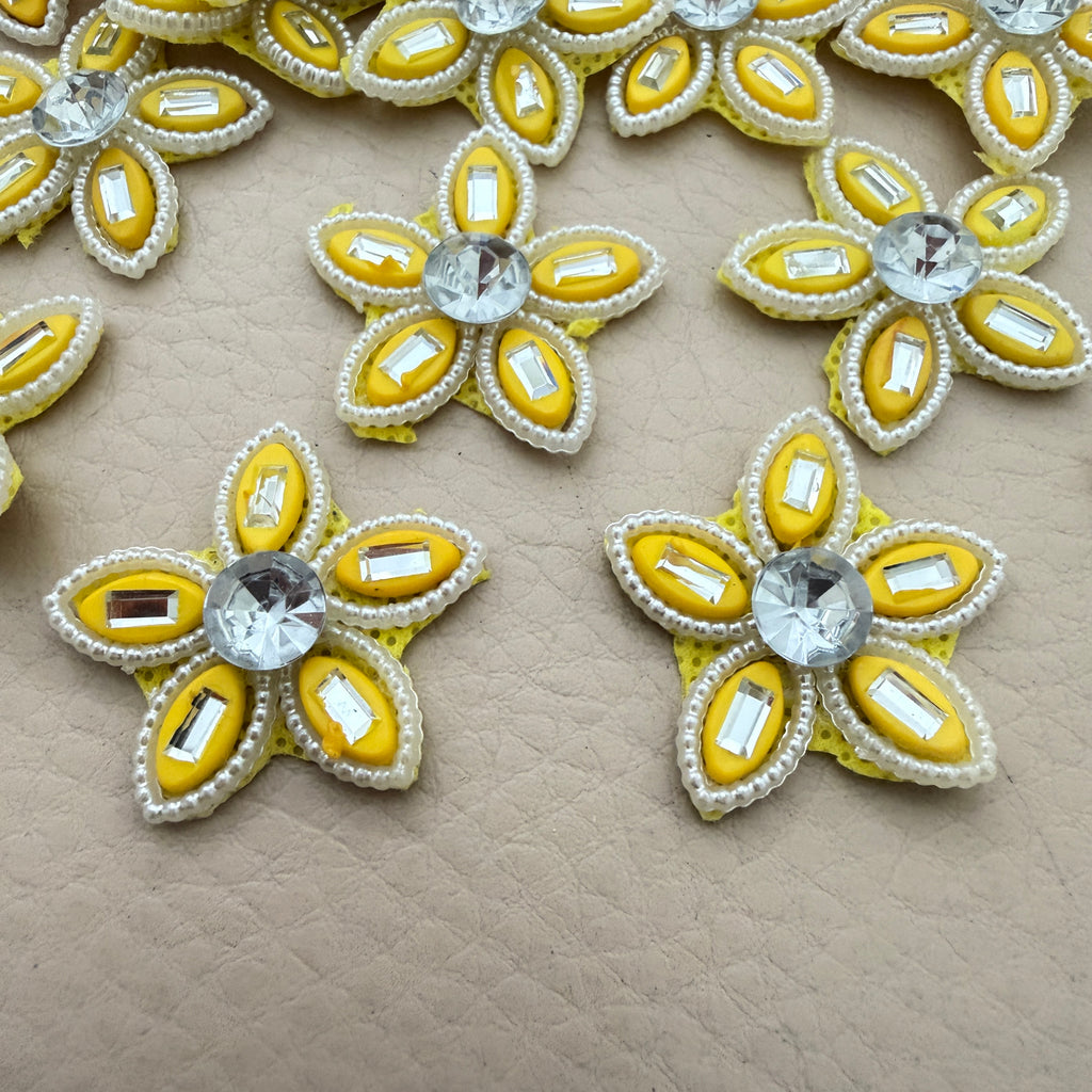 Two yellow rhinestone star flower motif patches showing front detail up close
