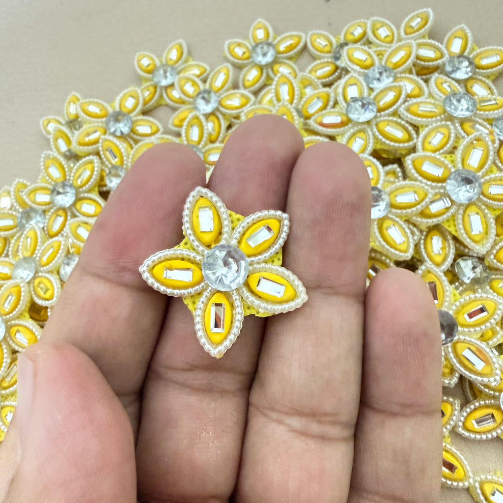 Yellow rhinestone star flower motif patch held in hand showing size
