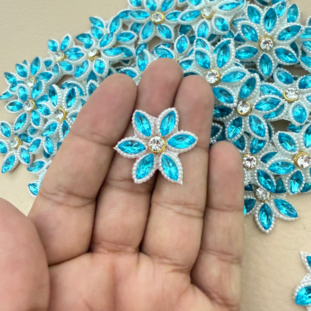 Aqua blue rhinestone star flower motif patch held in hand showing size