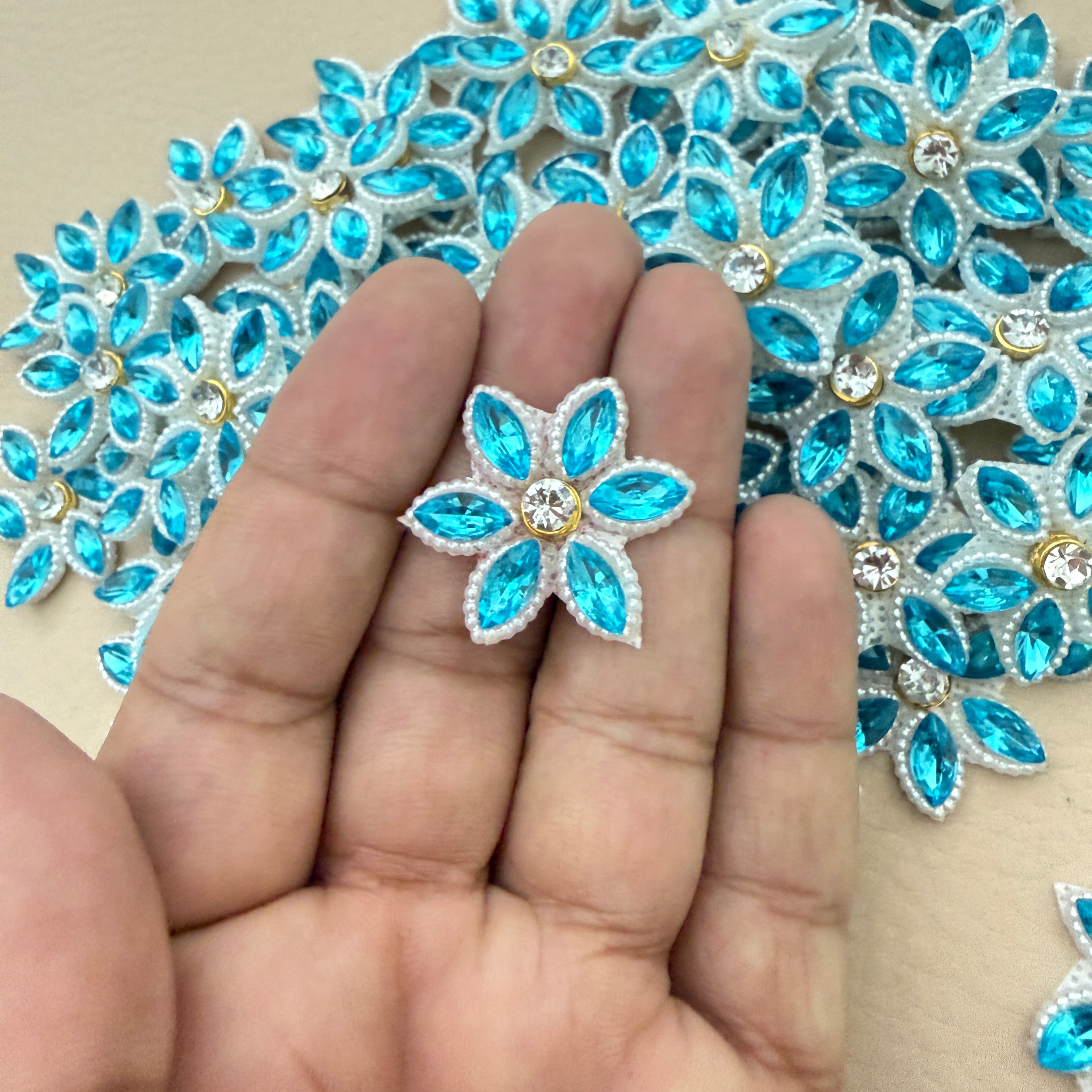 Aqua blue rhinestone star flower motif patch held in hand showing size