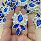 Hand holding royal blue rhinestone patch for size reference