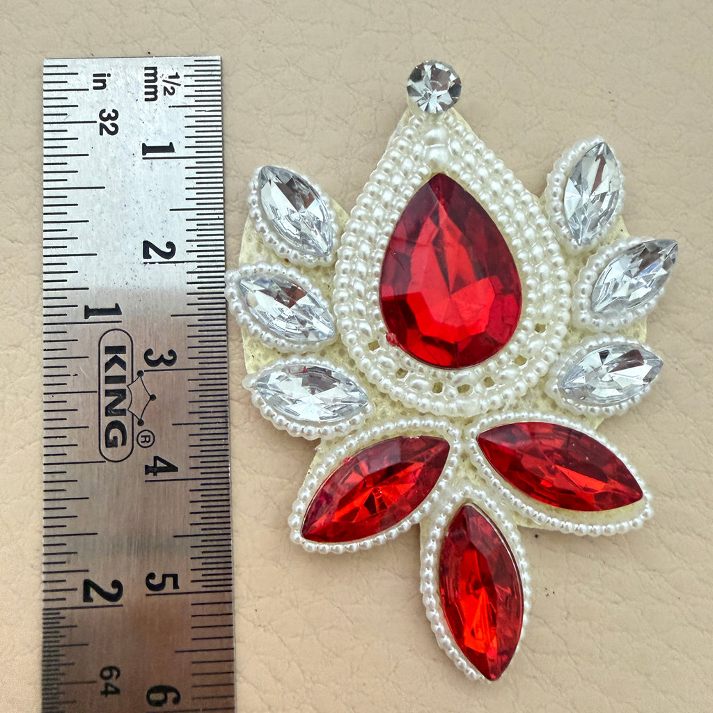 Ruby red rhinestone patch with ruler showing size approximately 6.5cm