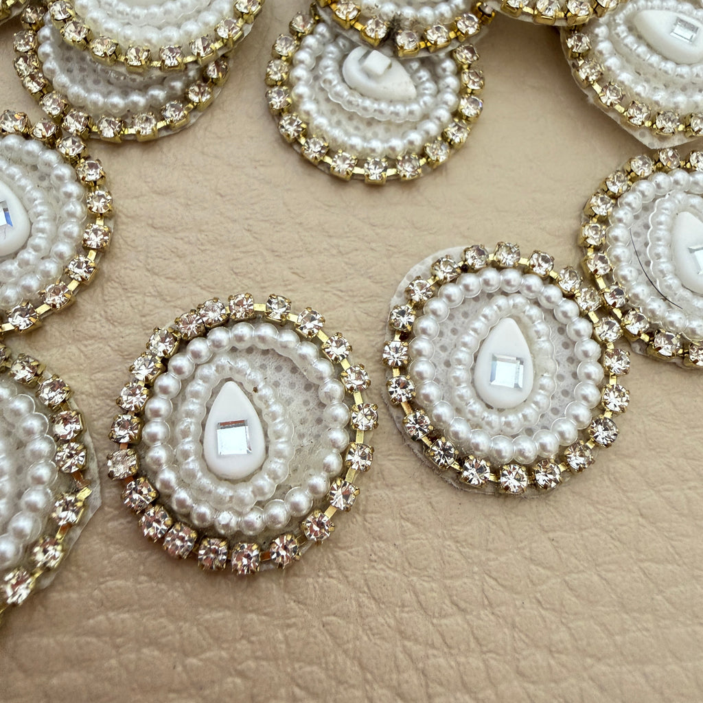 Close-up of a white pearl-style teardrop patch held in hand