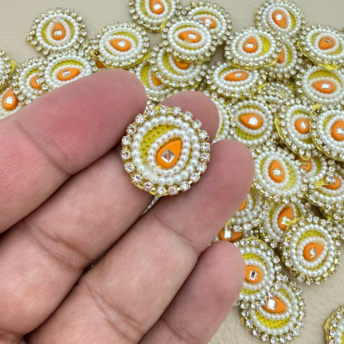 Close-up of a yellow pearl-style round patch held in hand