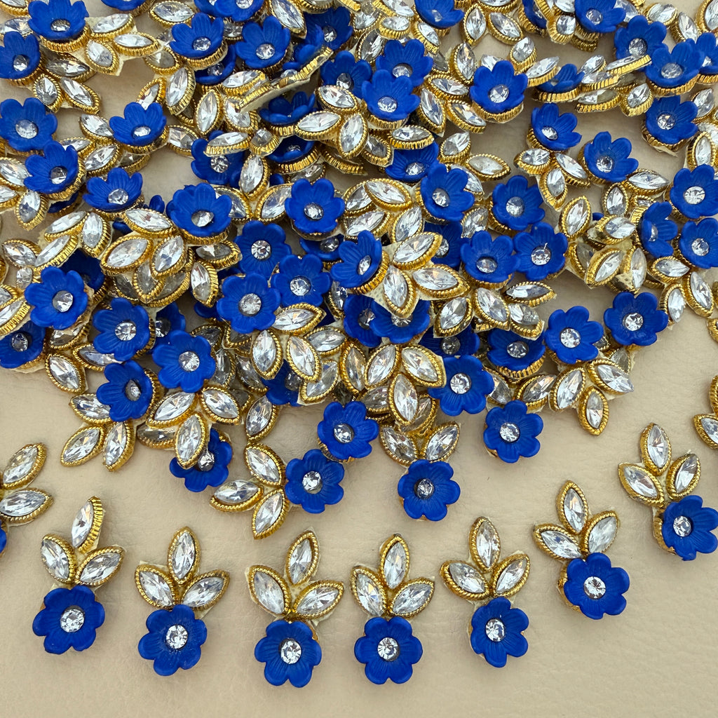 Blue flower patch with clear rhinestone-style leaf accents and gold-tone edging