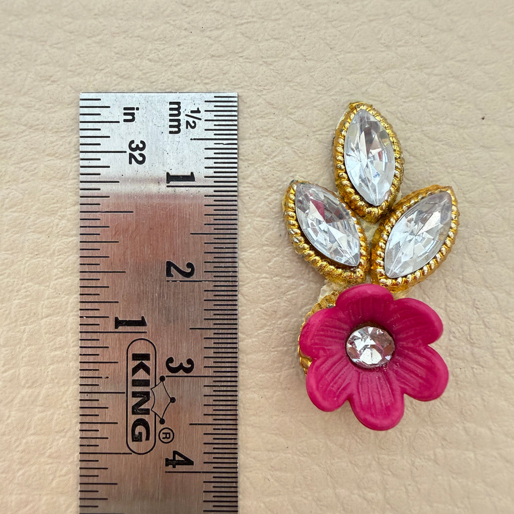 Pink flower and leaf applique patch placed beside a ruler for size reference