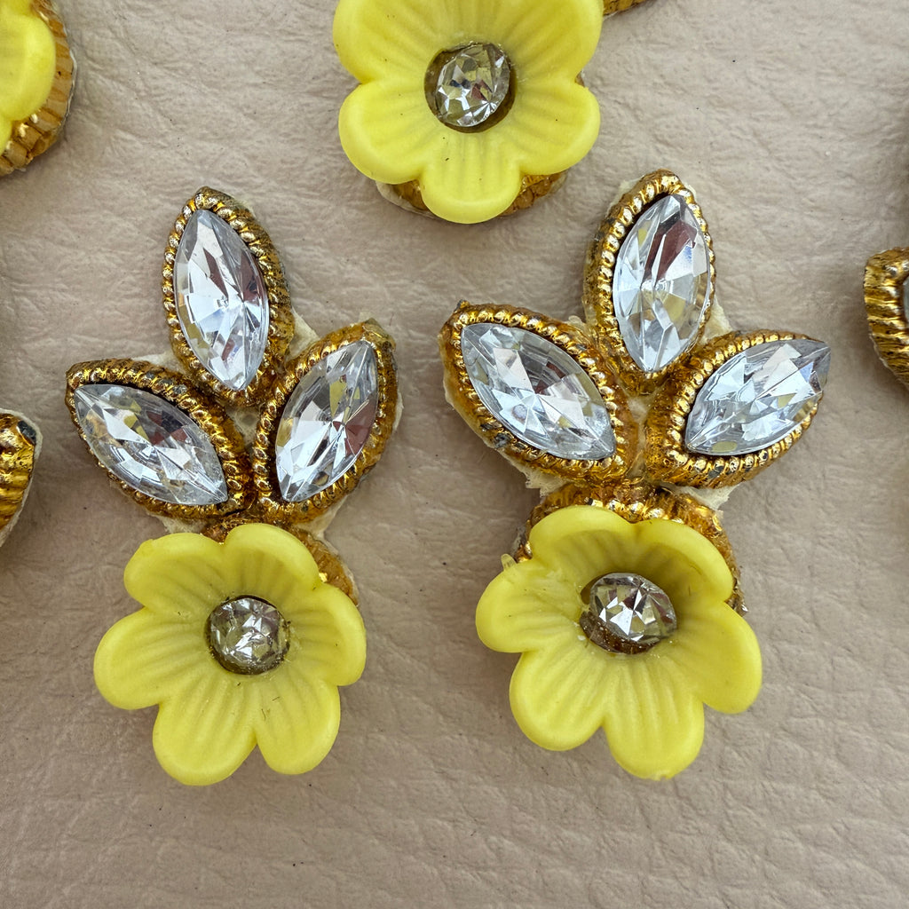 Yellow flower and leaf embellishment patch held in hand to show its compact size