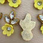 Yellow flower and leaf applique patch placed beside a ruler for size reference