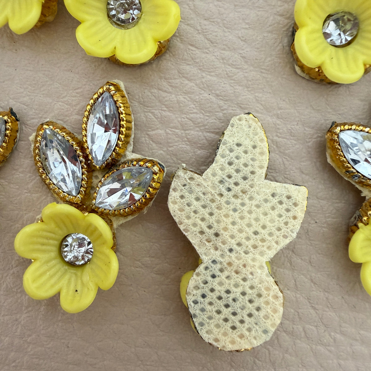 Yellow flower and leaf applique patch placed beside a ruler for size reference