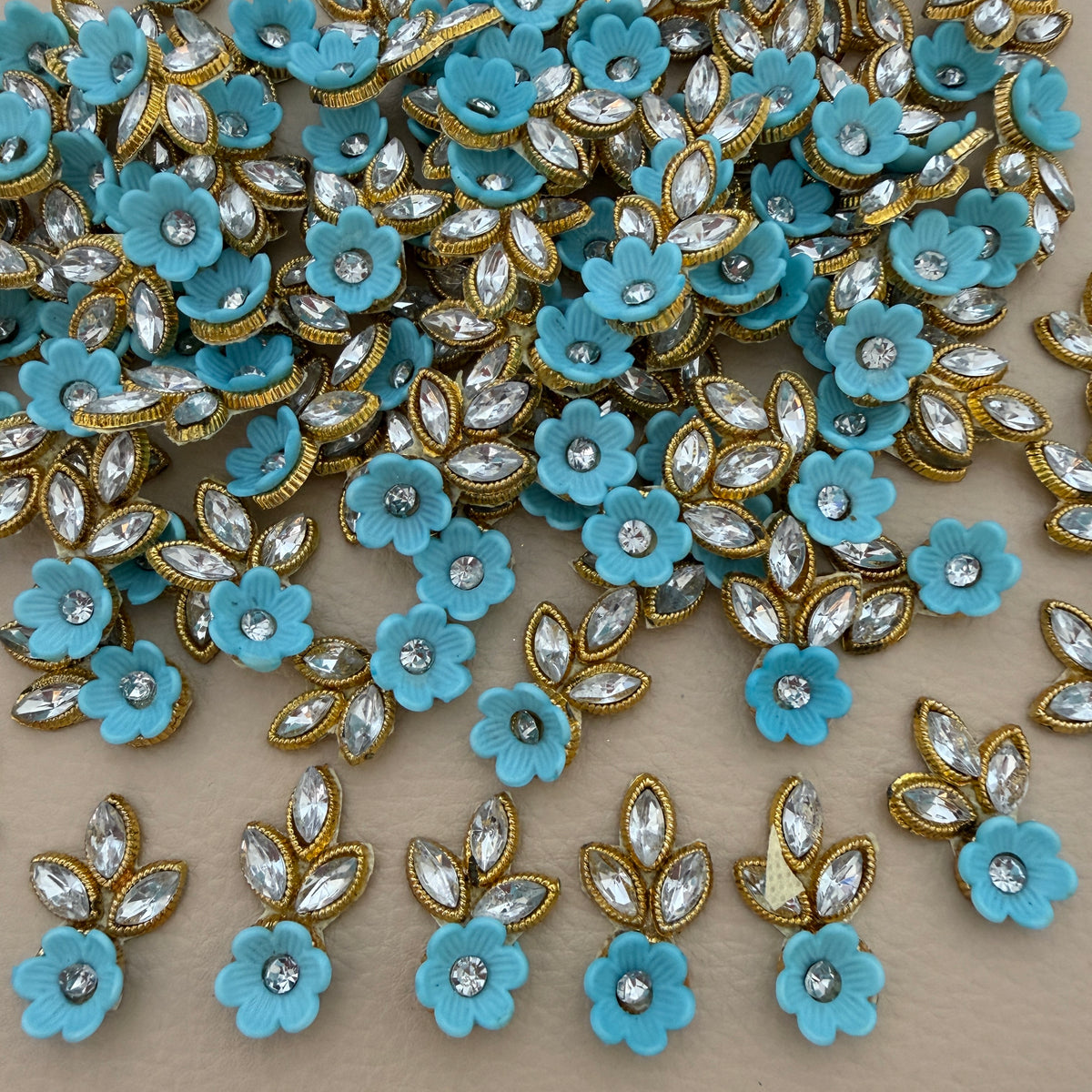 Sky blue flower and leaf applique patch with clear rhinestone-style stones and gold-tone edging