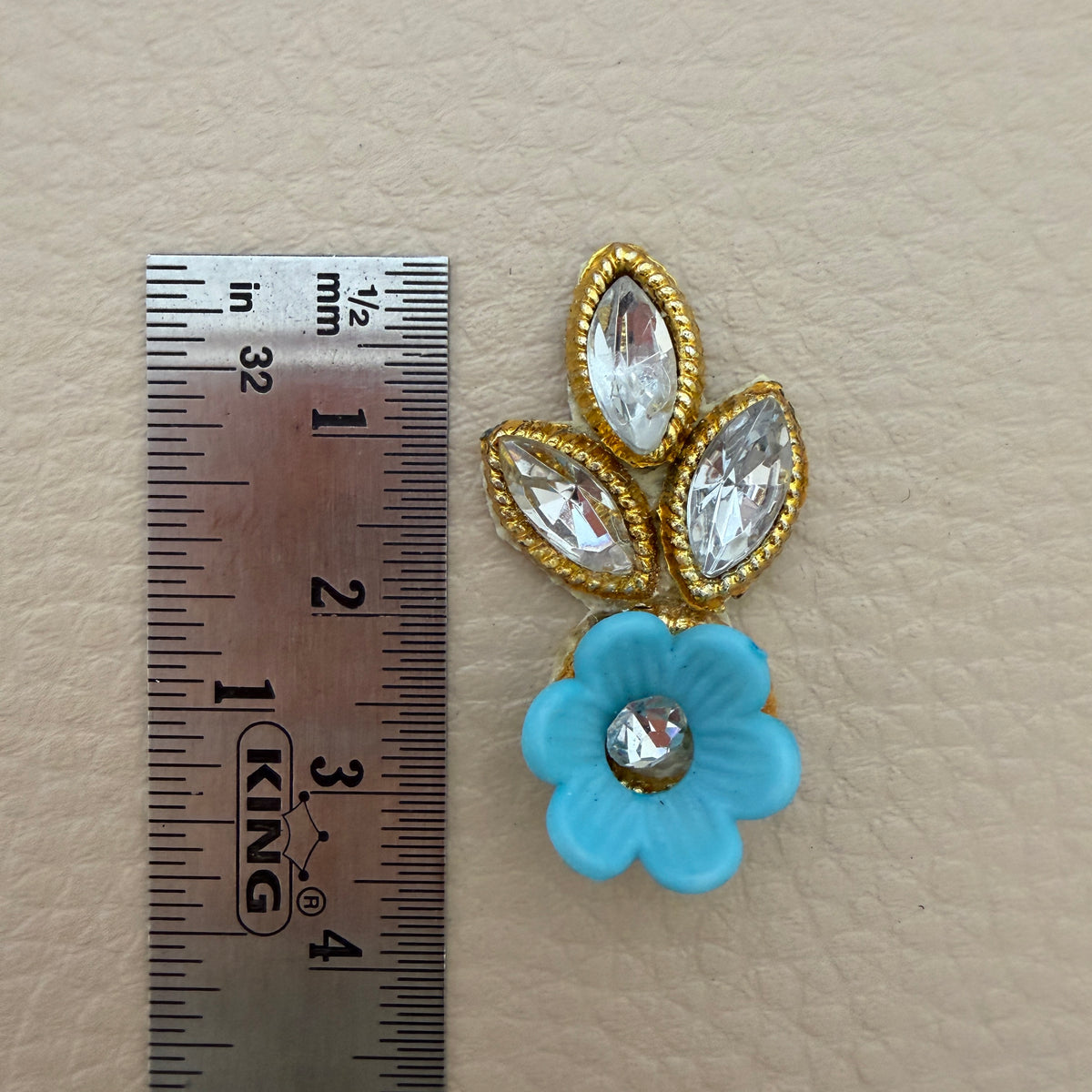 Back view of sky blue flower and leaf applique patch showing the light fabric backing