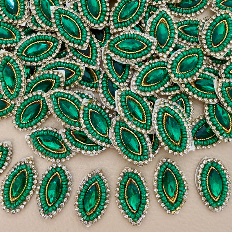 Emerald green marquise crystal patch with green beadwork, clear rhinestones, gold-tone detailing, and ivory mesh backing