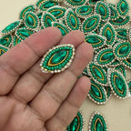 Emerald green crystal rhinestone patch placed beside a ruler for size reference