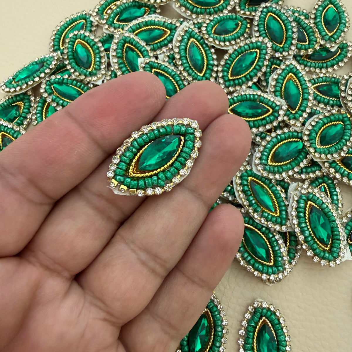 Emerald green crystal rhinestone patch placed beside a ruler for size reference