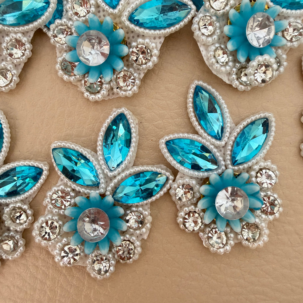 Sky blue crystal and pearl rhinestone applique patch placed beside a ruler for size reference